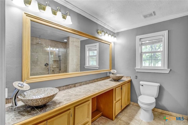 bathroom featuring vanity, toilet, ornamental molding, a textured ceiling, and walk in shower