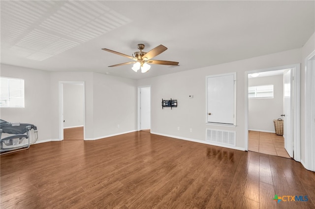 unfurnished living room with ceiling fan, wood-type flooring, and plenty of natural light