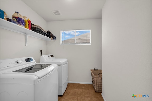 clothes washing area featuring washer and clothes dryer and light tile patterned floors