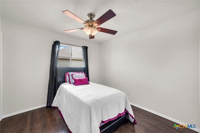 bedroom with dark hardwood / wood-style flooring and ceiling fan