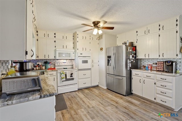 kitchen with light wood-type flooring, backsplash, a textured ceiling, white appliances, and ceiling fan