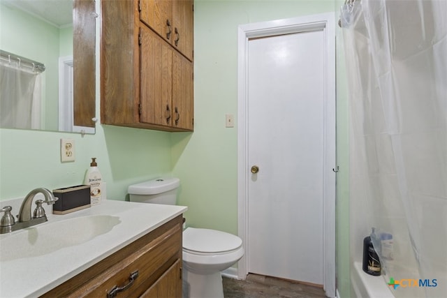 bathroom with a shower with shower curtain, hardwood / wood-style flooring, vanity, and toilet