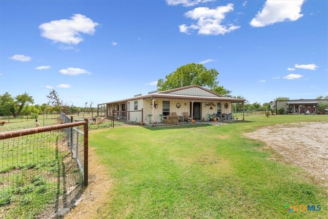 exterior space featuring a porch, a front yard, and a rural view