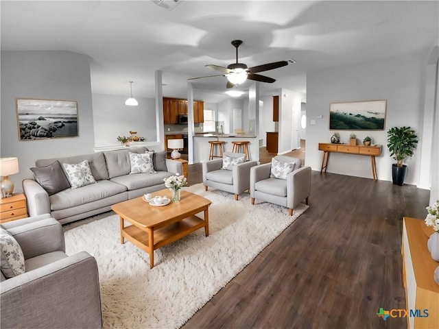 living room featuring ceiling fan and dark wood-type flooring