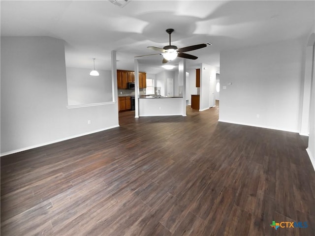 unfurnished living room featuring dark hardwood / wood-style flooring and ceiling fan