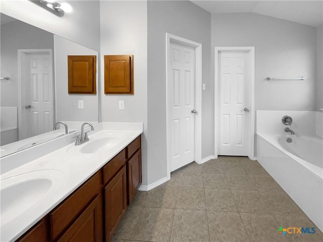 bathroom featuring a bathing tub, tile patterned flooring, vanity, and lofted ceiling