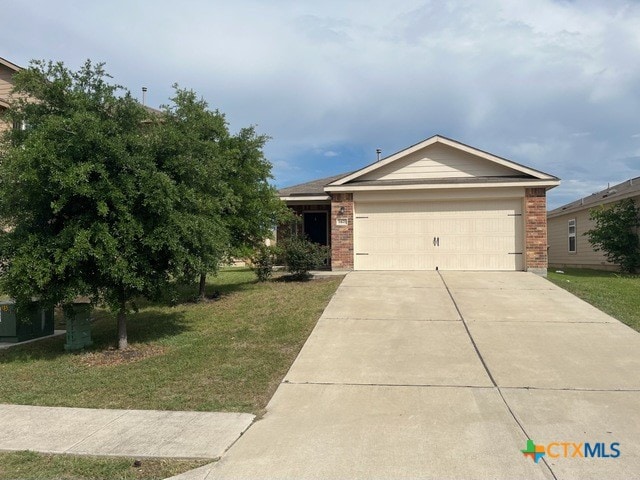 1421 Breanna Ln, Kyle, TX 78640 - ranch-style home with brick siding, a front lawn, an attached garage, and concrete driveway