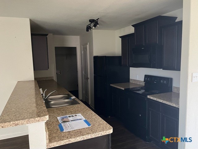 1421 Breanna Ln, Kyle, TX 78640 - kitchen with black appliances, a sink, light countertops, a peninsula, and dark wood-type flooring