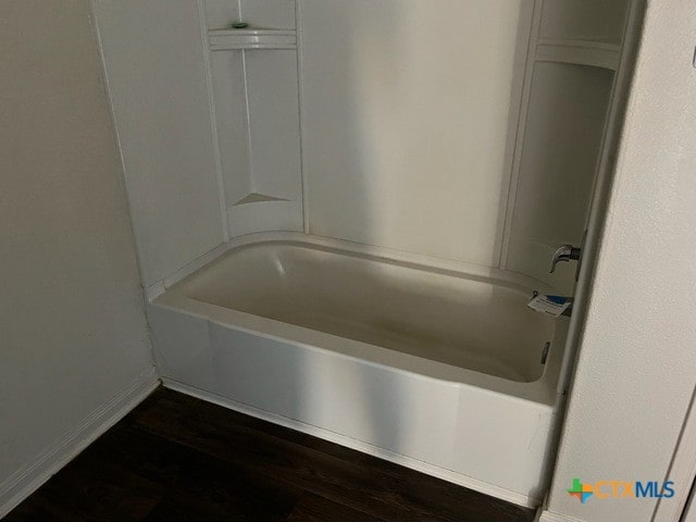 1421 Breanna Ln, Kyle, TX 78640 - bathroom featuring baseboards, wood finished floors, and shower / tub combination