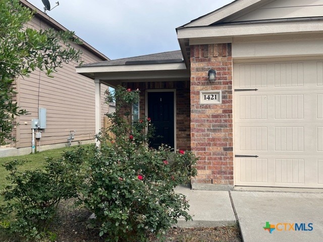 1421 Breanna Ln, Kyle, TX 78640 - view of exterior entry with brick siding and an attached garage