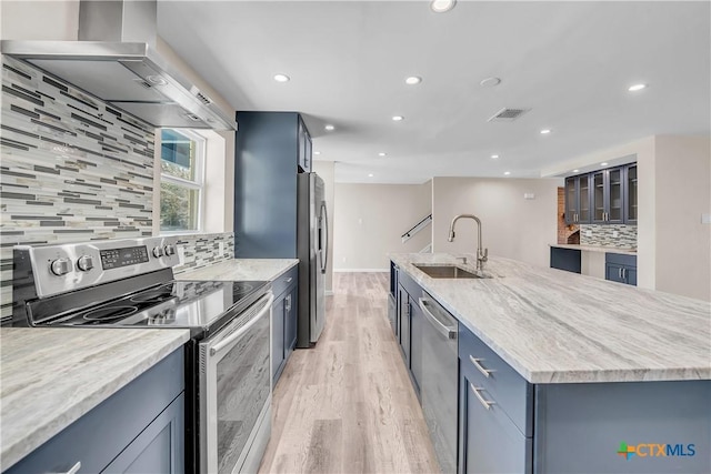 kitchen with a sink, visible vents, appliances with stainless steel finishes, a large island, and wall chimney exhaust hood