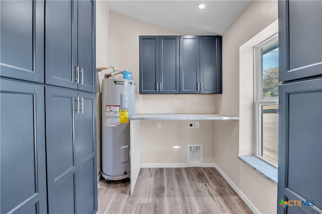 laundry room with cabinet space, light wood-style flooring, electric water heater, electric dryer hookup, and baseboards