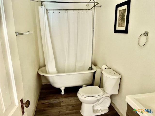 bathroom featuring hardwood / wood-style flooring, vanity, toilet, and a washtub