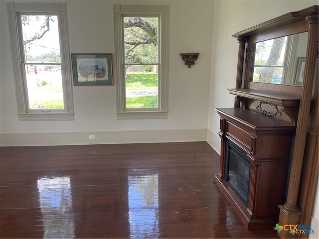 unfurnished living room with dark wood-type flooring