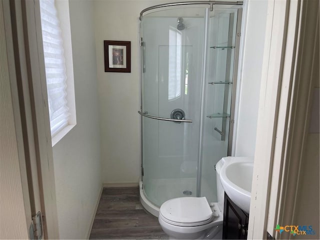 bathroom with vanity, wood-type flooring, toilet, and walk in shower