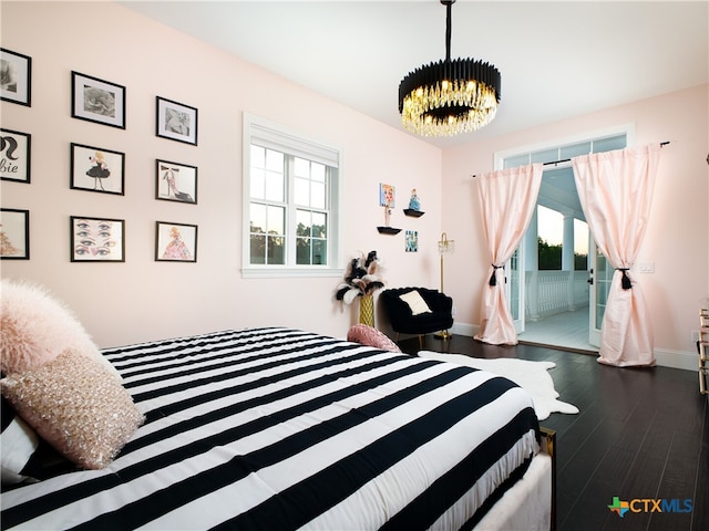 bedroom with baseboards, an inviting chandelier, and dark wood-style floors