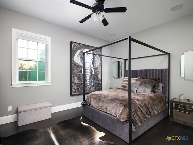 bedroom with ceiling fan, baseboards, and wood finished floors