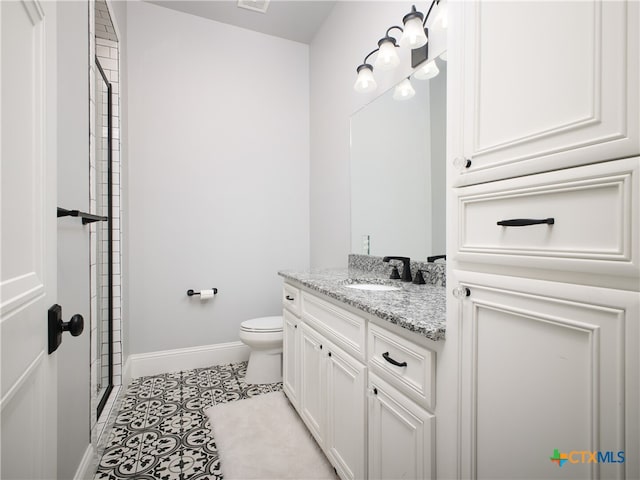 bathroom with baseboards, toilet, tile patterned floors, vanity, and a shower