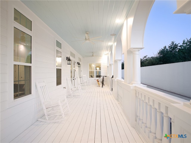 wooden terrace with a porch and a ceiling fan