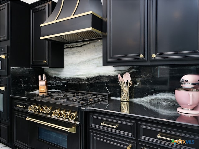 kitchen with custom exhaust hood, range with gas cooktop, dark cabinetry, and tasteful backsplash