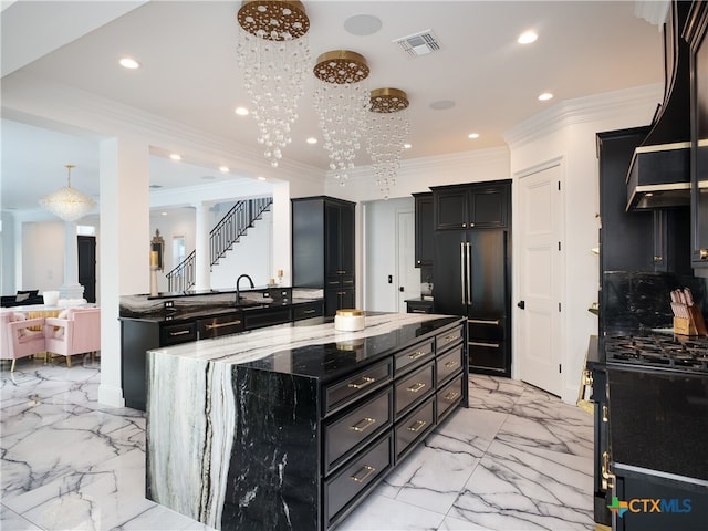 kitchen featuring black range with gas cooktop, high end fridge, visible vents, and dark cabinets