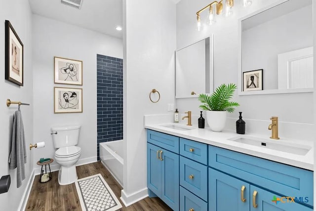 107 Onini Ct, Bastrop, TX 78602 - bathroom featuring toilet, double vanity, wood finished floors, shower / bathtub combination, and baseboards