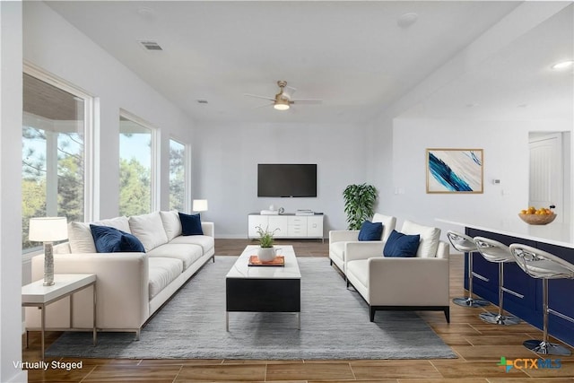 living area with wood finish floors, visible vents, ceiling fan, and recessed lighting