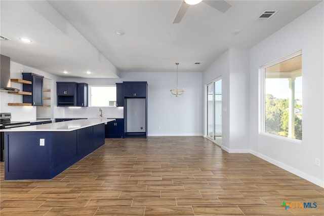 107 Onini Ct, Bastrop, TX 78602 - kitchen with open shelves, light wood-style floors, blue cabinetry, a center island, and ceiling fan