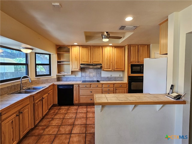 kitchen featuring tile counters, sink, black appliances, and kitchen peninsula