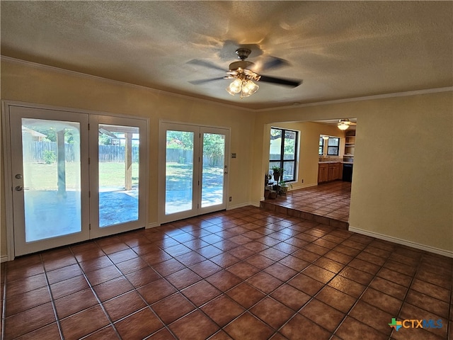 tiled spare room featuring ornamental molding, a wealth of natural light, and a textured ceiling