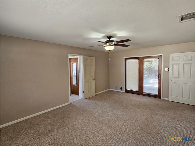 spare room with ceiling fan and light carpet