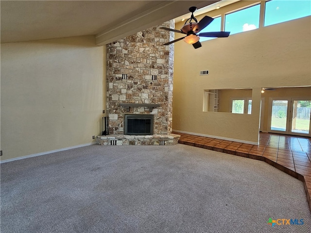 unfurnished living room featuring a fireplace, high vaulted ceiling, tile patterned flooring, beamed ceiling, and ceiling fan