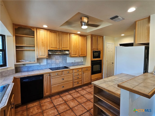 kitchen featuring tile counters, kitchen peninsula, black appliances, and ceiling fan