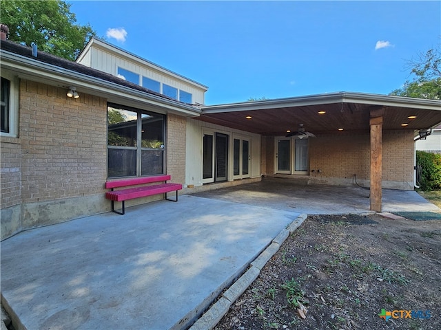 back of property featuring ceiling fan and a patio