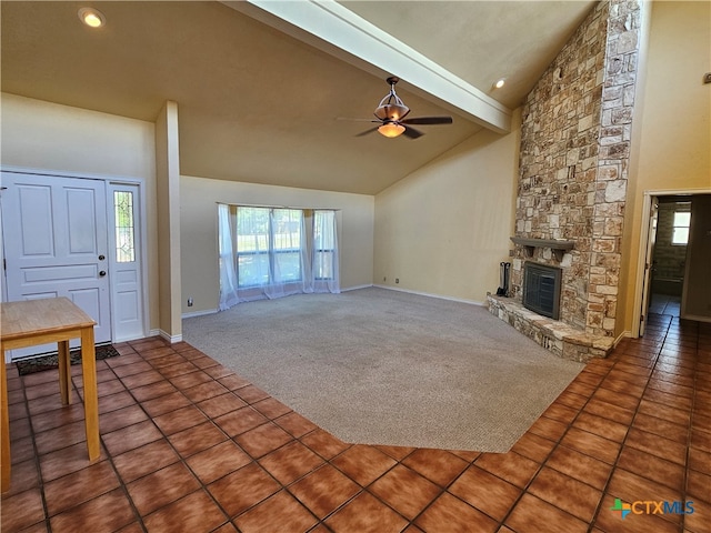 unfurnished living room with tile patterned floors, high vaulted ceiling, beamed ceiling, ceiling fan, and a fireplace