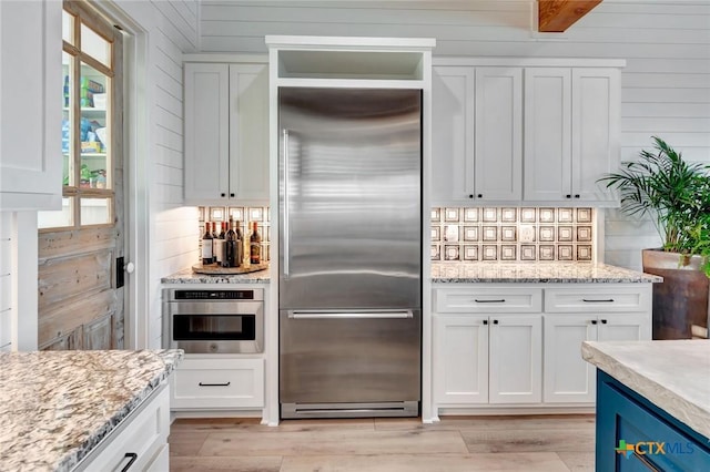 kitchen featuring white cabinets, appliances with stainless steel finishes, and plenty of natural light