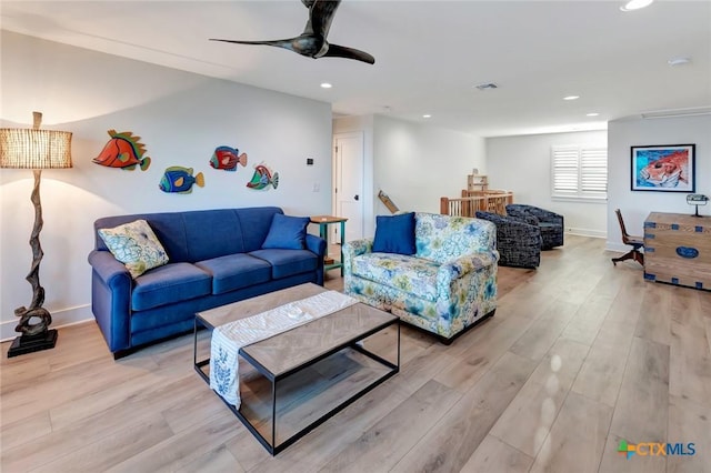 living room featuring ceiling fan and light hardwood / wood-style floors