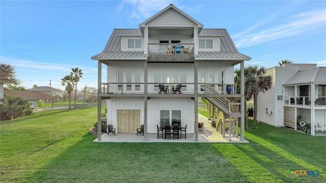 back of house featuring a lawn, a patio area, and a balcony