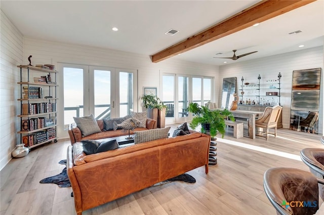 living room featuring beam ceiling, ceiling fan, french doors, and light hardwood / wood-style floors