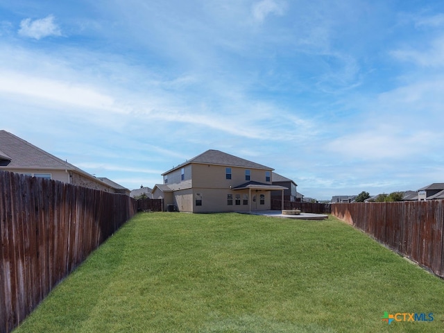 back of house featuring a lawn and a patio