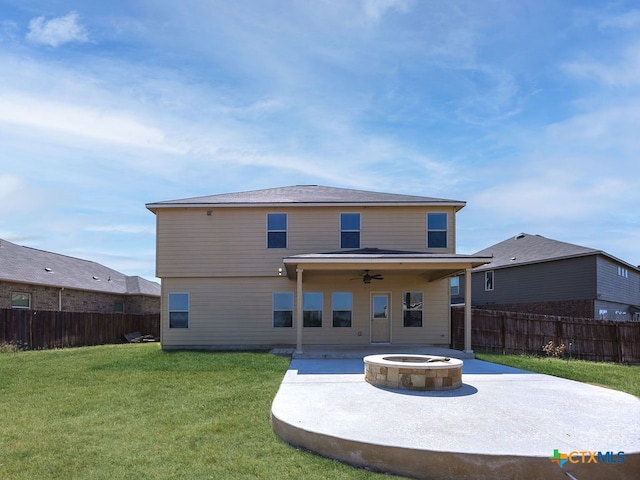 rear view of house with a fire pit, ceiling fan, a yard, and a patio area