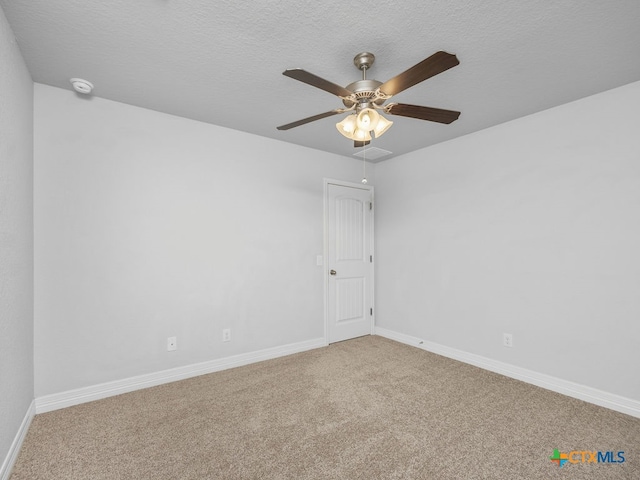 spare room featuring a textured ceiling, carpet flooring, and ceiling fan