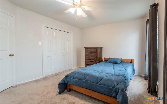 bedroom featuring ceiling fan, light colored carpet, and a closet