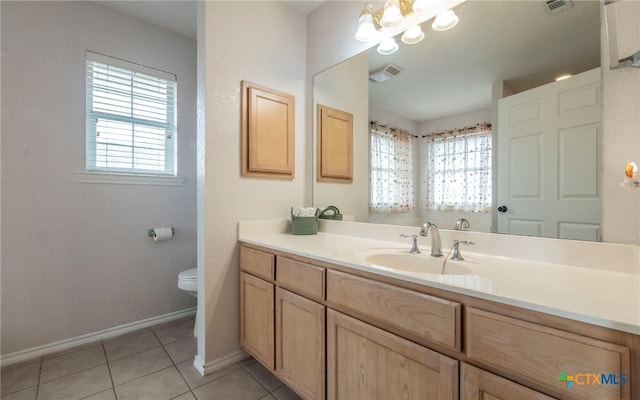 bathroom featuring tile patterned floors, an inviting chandelier, toilet, and a healthy amount of sunlight