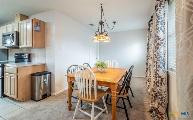 tiled dining room featuring a chandelier