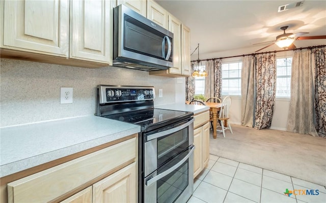 kitchen with light tile patterned floors, ceiling fan, appliances with stainless steel finishes, tasteful backsplash, and pendant lighting