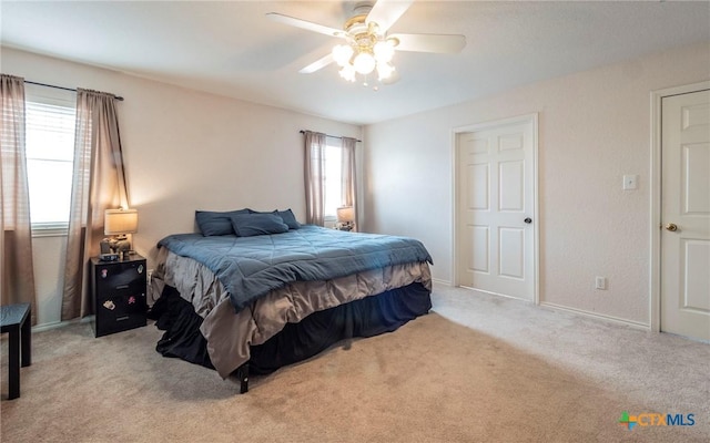 carpeted bedroom featuring ceiling fan and multiple windows