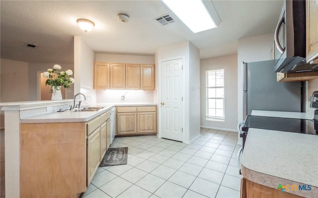 kitchen featuring kitchen peninsula, stainless steel appliances, light brown cabinets, light tile patterned flooring, and sink