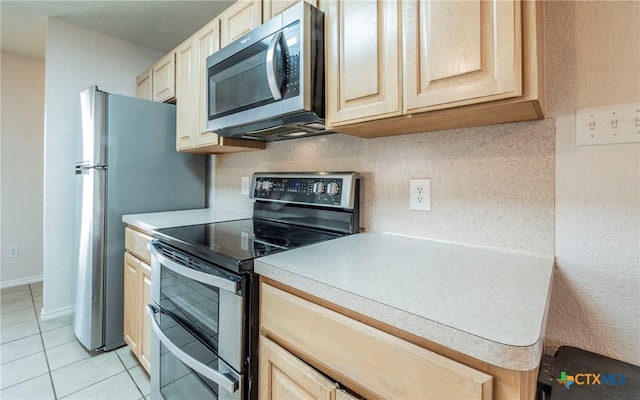 kitchen featuring tasteful backsplash, light tile patterned floors, appliances with stainless steel finishes, and light brown cabinets