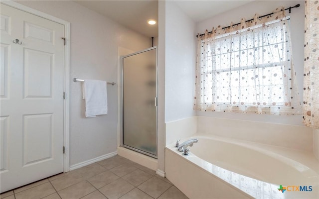 bathroom featuring a wealth of natural light, separate shower and tub, and tile patterned flooring